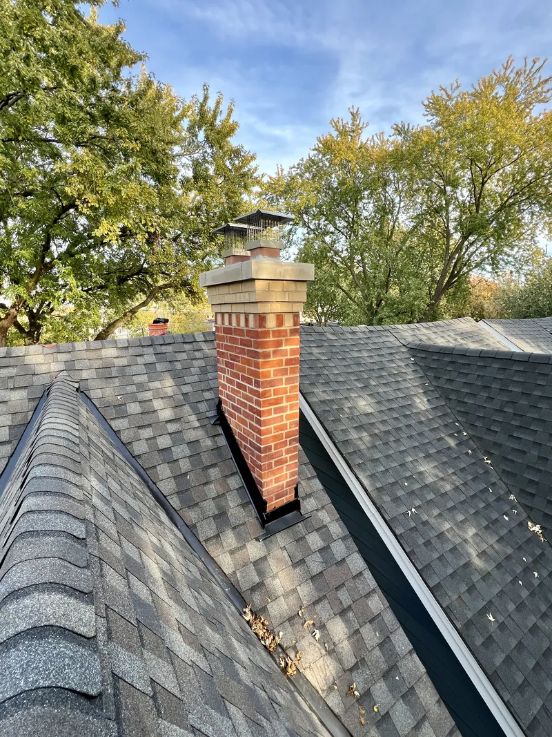 Completed red and buff brick chimney rebuild with a cast stone crown, Toronto roof
